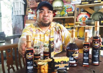 MOHD. Sufian Mat Noor menunjukkan antara produk madu kelulut perusahaannya yang dijual di Galeri Madu Kelulut Bukit, Bukit Bayas, Kuala Terengganu. – UTUSAN/TENGKU DANISH BAHRI TENGKU YUSOFF