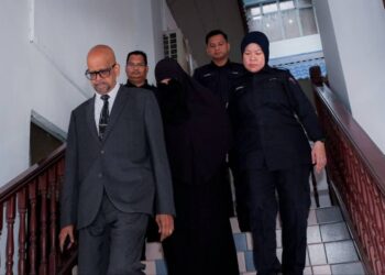 TERTUDUH (tengah) diiring keluar peguamnya dan anggota polis selepas mengaku tidak bersalah di Mahkamah Sesyen, Ayer Keroh, Melaka. - UTUSAN/SYAFEEQ AHMAD