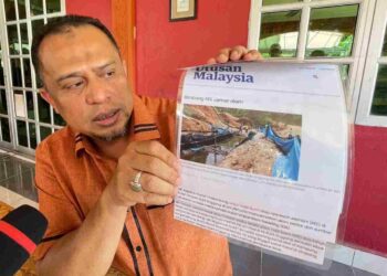 MAHADZIR Abdul Hamid menunjukkan keratan akhbar Utusan Malaysia dalam sidang akhbar berkenaan isu REE di Kampung Tala, Sik. – UTUSAN/ SHAHIR NOORDIN