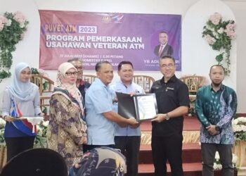 ADLY Zahari (dua dari kanan) menyampaikan geran padanan SPKLB kepada salah seorang usahawan Veteran ATM sempena Majlis Pelancaran Puvet ATM di Kampung Baru Si Rusa, Port Dickson hari ini.-UTUSAN/NOR AINNA HAMZAH.