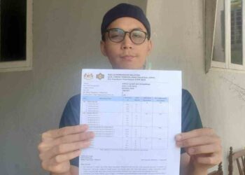 AHMAD Ilham Mohamad menunjukkan keputusan STPM yang diumumkan kelmarin.
