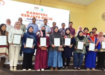 MOHAMAD Hasan (baris belakang, empat dari kiri) bergambar bersama pencarum Skim Pekerjaan Sendiri dan Skim Keselamatan Sosial Suri Rumah Perkeso semepan Majlis Perasmian Karnival Kerjaya Belia Parlimen Rembau, di Rembau hari ini.-UTUSAN/NOR AINNA HAMZAH.