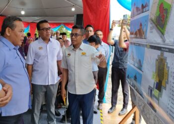 AMINUDDIN Harun (kiri) diberikan penerangan mengenai reka bentuk masjid pada Majlis Pecah Tanah Pembinaan Masjid Baharu Taman Bukit Kepayang di Seremban hari ini.-UTUSAN/NAZARUDIN SHAHARI.