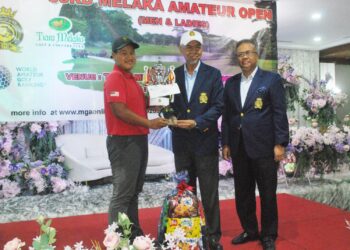 MUHAMMAD ADIF HAIKAL Md. Hazan menerima hadiah selaku juara disampaikan Mohd. Anwar Mohd. Nor di Kelab Golf Tiara & Country, Melaka. - UTUSAN/AMRAN MULUP