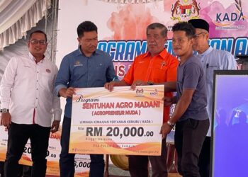 MOHAMAD Sabu (tengah) menyampaikan geran bantuan Agropreneur Muda KADA di Pasar Tamu, Beris Kubur Besar, Bachok, Kelantan hari ini. UTUSAN/TOREK SULONG