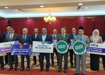 MUHAMMAD Sanusi Md. Nor (tengah) menerima zakat perniagaan Kumpulan PKNK di Wisma Darul Aman, Alor Setar.