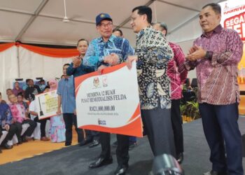 ANWAR Ibrahim ketika menyampaikan replika sumbangan sempena Program Karnival Segalanya Felda di Dataran Seri Jempol, Feldajaya Selatan Wilayah Raja Alias, di Jempol hari ini.-UTUSAN/NOR AINNA HAMZAH.