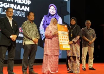 FUZIAH Salleh (tiga kiri) menyerahkan replika sebagai gimik bantuan tanpa tunai kepada salah seorang pelajar di Kota Bharu, Kelantan hari ini-UTUSAN/ROHANA ISMAIL