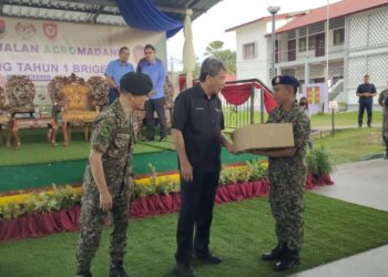 MOHAMAD Hasan ketika menyampaikan sumbangan sempena Program Jualan Agro Madani di Kem Rasah, Seremban hari ini.-UTUSAN/NOR AINNA HAMZAH.