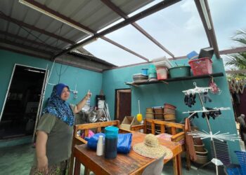 AISHAH Abdul Ghani menunjukkan keadaan bumbung rumahnya yang rosak selepas dibadai belalai darat dalam kejadian di Kampung Balik Batu, Tanjung Bidara, Alor Gajah, Melaka.