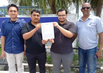 HAZMI NABIL Mahmad Faisaal (dua dari kanan) bersama Ketua Angkatan Muda Keadilan (AMK) Cabang Alor Gajah, B. Dinesh (dua dari kiri) menunjukkan laporan polis dibuat di IPD Alor Gajah, Melaka. - UTUSAN/AMRAN MULUP