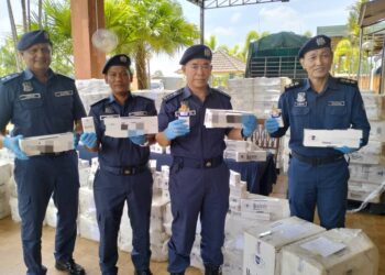 WAN Jamal Abdul Salam Wan Long (tengah) menunjukkan rokok seludup yang dirampas di Pejabat Penguatkuasa JKDM Rantau Panjang, Kelantan-UTUSAN/ ROHANA ISMAIL.