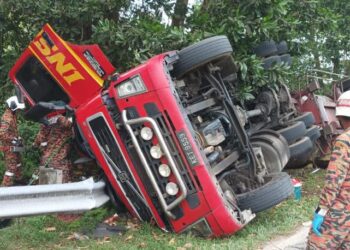 ANGGOTA Bomba berusaha mengeluarkan dua mayat mangsa yang tersepit dalam lori minyak kelapa sawit di Jalan Paloh 3 - Lebir, Gua Musang, Kelantan hari ini.-IHSAN BOMBA