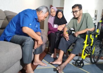 AHMAD Said memperkatakan sesuatu kepada Azlan Bahrum di kediamannya di  Pangsapuri Ladang Tok Pelam, Kuala Terengganu,  hari ini. - UTUSAN/KAMALIZA KAMARUDDIN