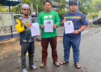 Mohd Azizi Syam Samsudin (dua dari kanan) menunjukkan laporan kenyataan dikeluarkan oleh Lim Guan Eng sebelum membuat laporan di Ibu Pejabat Polis Daerah (IPD) Kangar, Perlis, hari ini.- UTUSAN/ASYRAF MUHAMMAD