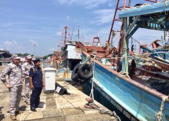 HAMID Mohd. Amin  (kiri) melihat antara bot yang dirampas dalam Op Marfdor di jeti Pejabat Maritim Malaysia Negeri Terengganu di Kuala Terengganu, hari ini. - UTUSAN/TENGKU DANISH BAHRI TENGKU YUSOFF