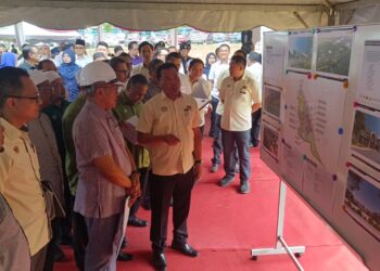 AHMAD Samsuri Mokhtar (tiga dari kiri) diberi taklimat mengenai pembinaan Sekolah Menengah Imtiaz Yayasan Terengganu di Kampung Tok Muchong, Marang, hari ini.