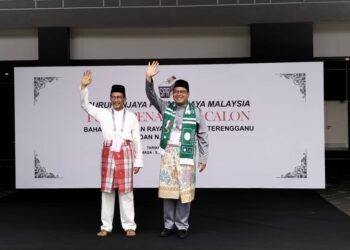 AHMAD Amzad (kanan) dan Azan Ismail mengangkat tangan selepas diumumkan sebagai calon PRK Parlimen Kuala Terengganu di Kuala Terengganu, hari ini. - UTUSAN/KAMALIZA KAMARUDDIN
