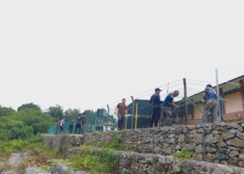 ANGGOTA Perhilitan memasang pagar elektrik di SK Pos Perwor, Lasah di Sungai Siput bagi mengatasi ancaman gajah liar. - UTUSAN