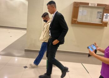 AHMAD AKMI Mohamad (kanan) diiringi pegawai Suruhanjaya Pencegahan Rasuah Malaysia (SPRM) keluar dari kamar Mahkamah Sesyen Kuantan di Kuantan, Pahang. - UTUSAN/DIANA SURYA ABD WAHAB