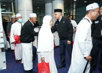 SYED Hamadah Syed Othman bersalaman dengan kumpulan pertama jemaah haji Malaysia pulang ke tanah air di KLIA Sepang. GAMBAR IHSAN TABUNG HAJI