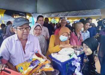 FUZIAH Salleh (tengah) meninjau aktiviti pembelian barangan keperluan oleh pengunjung sempenan pelancaran Jualan Rahmah bergerak di Taman Ria Jaya, Sungai Petani.