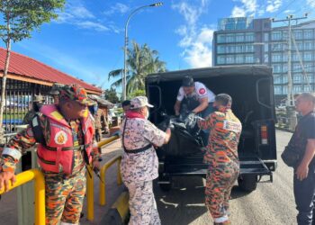 ANGGOTA bomba menyerahkan mayat mangsa bot karam di perairan Pulau Nusa Tengah kepada polis di Semporna, Sabah, hari ini. - IHSAN BOMBA