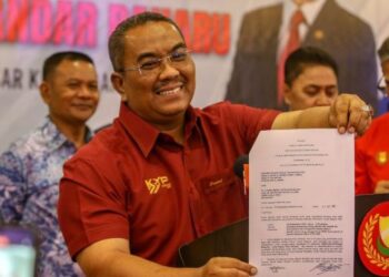 MUHAMMAD Sanusi Md. Nor menunjukkan notis kompaun yang dikeluarkan PTG Kedah kepada pihak yang menceroboh dan mencuri nadir bumi REE di Sik pada sidang akhbar di Bandar Baharu, hari ini. - UTUSAN/SHAHIR NOORDIN