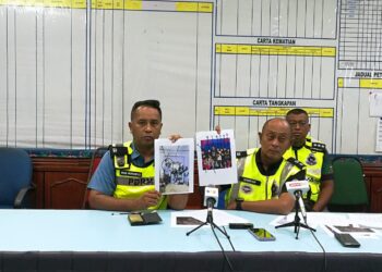 HANYAN Ramlan  (tengah) menunjukkan gambar 10 individu yang dikhuatiri hilang ekoran kepala air di Jeram Mawar, Air Putih, Kemaman, - UTUSAN/NIK NUR IZZATUL HAZWANI NIK ADNAN