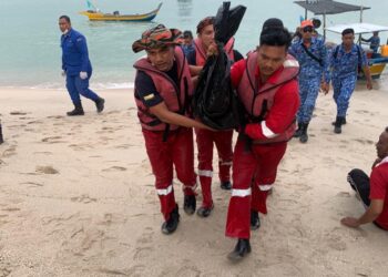 ANGGOTA bomba membawa mayat kanak-kanak yang ditemukan lemas di Pantai Teluk Senangin, Segari hari ini. - UTUSAN/IHSAN JBPM PERAK