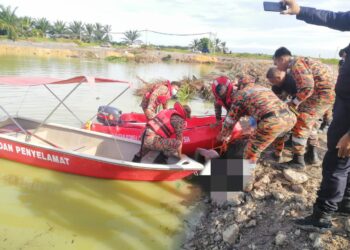 ANGGOTA bomba mengangkat naik mayat mangsa lemas di lombong dekat Jalan Bidor-Teluk Intan, Bidor hari ini. - UTUSAN/IHSAN JBPM