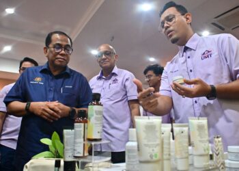 MOHAMED Khaled Nordin (kiri) diberi penerangan oleh salah seorang pensyarah UMT mengenai produk penjagaan kulit halal selepas melakukan lawatan kerja di universiti itu di Kuala Nerus, hari ini. - UTUSAN/KAMALIZA KAMARUDDIN