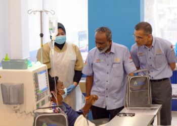 Sivakumar (tengah) dan Ketua Pegawai Eksekutif Kumpulan PERKESO, Dato’ Sri Dr. Mohammed Azman Aziz Mohammed ketika menyantuni seorang pesakit yang menerima rawatan di Pusat Dialisis PERKESO di Klang pada Khamis.