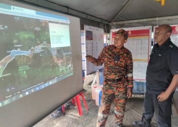 AZMAN Alias (kiri) memberi taklimat mengenai operasi SAR mangsa kepala air di Jeram Mawar, Air Bukit, Kemaman, hari ini. - UTUSAN/NIK NUR IZZATUL HAZWANI NIK ADNAN