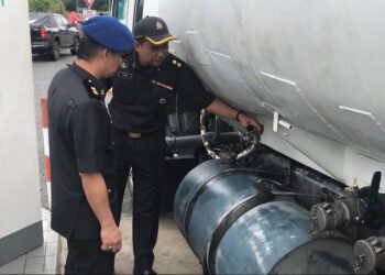 PEGAWAI KPDN memeriksa tangki sebuah lori yang digunakan untuk menyeleweng diesel di Paka, Dungun, hari ini. - UTUSAN/NIK NUR IZZATUL HAZWANI NIK ADNAN