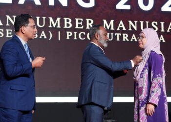 V. Sivakumar menyampaikan pingat dan sijil penghargaan perkhidmatan cemerlang kepada Habsah Md. Ishak (kanan) pada Majlis APC KSM Tahun 2022 di Putrajaya. - UTUSAN/FAISOL MUSTAFA