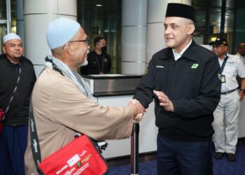 SYED Hamadah Syed Othman bersalaman dengan kumpulan pertama jemaah haji Malaysia pulang ke tanah air di KLIA Sepang. - GAMBAR IHSAN TH