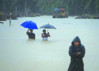 PENDUDUK mengharungi banjir di Kampung Teladas, Kemaman, pada Disember tahun lalu. - UTUSAN/PUQTRA HAIRRY ROSLI