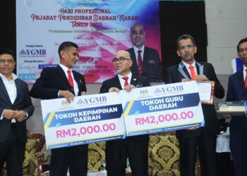 WAN MUNADI Wan Mamat (kiri) mengiringi Mohammad Rosli Abdul Rahman (tiga dari kiri) menyampaikan anugerah tokoh guru dan tokoh kepimpinan daerah Maran kepada dua guru pada program Hari Profesional Pejabat Pendidikan Daerah Maran di Maran, Pahang