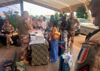 WARGANEGARA Perancis dan Eropah mendaftar sebelum menaiki penerbangan di luar terminal berlepas Lapangan Terbang Antarabangsa Diori-Hamani di Niamey,Niger.-AFP