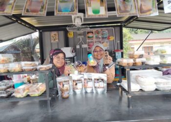 INTAN SYAFINAZ ABU TALIB  (kiri) dan Siti Asrina Miswan menunjukkan pelbagai produk yang dijual di Pondok Kuning Ice Station di Jalan Kampung Parit Panjang, Ayer Baloi, Pontian.