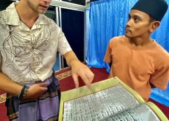 RUTGER (kiri) sedang mendengar penjelasan tentang al-Quran daripada pengurusan masjid di Kampung Kuala Tahan di Jerantut, Pahang.