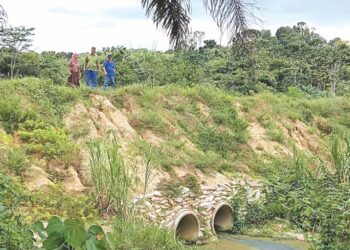 PENDUDUK Kampung Melayu Bukit Tarik menunjukkan laluan yang pernah runtuh akibat hakisan air pada tahun lalu dan dibina semula dengan kos ditanggung oleh penduduk sendiri.