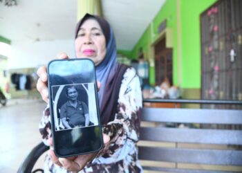 MAZNAH Abdullah,68, menunjukkan gambar sepupunya, Sharipuddin Shaari, 53, yang turut menjadi mangsa nahas pesawat terhempas di Elmina, Seksyen U16, Shah Alam di Jalan Rani Estate, Arau, Perlis hari ini.- UTUSAN/IZLIZAN OTHMAN