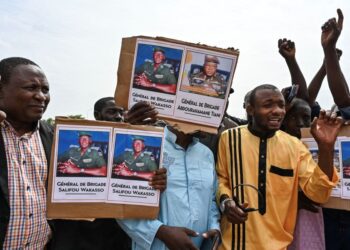 PENYOKONG junta tentera mengangkat sepanduk gambar Jeneral Abdorahamane Tiani ketika menyertai perhimpunan di Stadium Niamey.-AFP