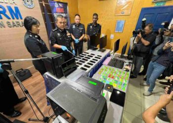 MANCHA (dua dari kiri) menunjukkan kesemua barangan rampasan yang digunakan oleh suspek dalam operasi penipuan terbabit, dalam sidang media di IPK Kuching hari ini.