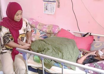 SHAHMIZA Yaakob tabah menjaga Nur Iman Qaseh Az Zahra Mohd. Haiman menderita sakit jantung dan paru-paru yang hanya mampu terlantar di atas katil sejak dua tahun lalu di kediamannya di Kampung Kurnia di Kuantan, Pahang. - UTUSAN/DIANA SURYA ABD WAHAB