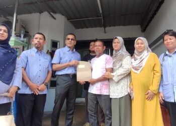 MOHAMMED Azman Aziz Mohammed (tiga dari kiri) menyerahkan dokumen bayaran FPM kepada Muhammad Saleh Othman selaku waris yang menerima faedah terhadap mangsa nahas pesawat di Sidam, Sungai Petani.