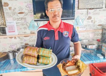 MOHAMMAD Khazim Ahmad menunjukkan hidangan burasak 
dan lepat loi yang dijual di kedainya di Kampung Parit Abd. Rahman, Benut, Pontian.