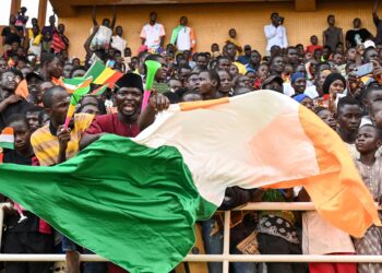 PENYOKONG junta tentera Niger mengibarkan bendera kebangsaan di Niamey. - AFP